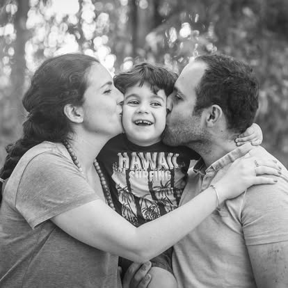 הורים מנשקים את הילד – צילום משפחה בשחור לבן