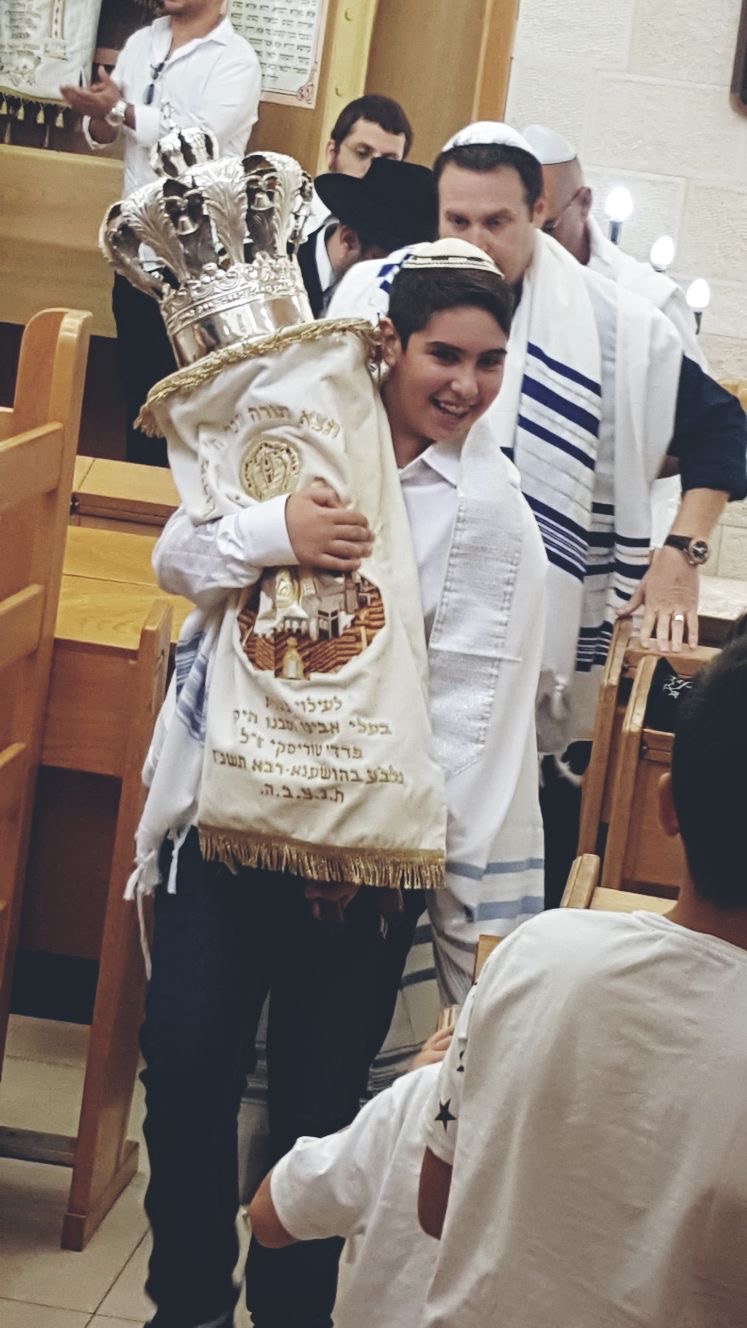 חתן בר המצווה נושא את ספר התורה