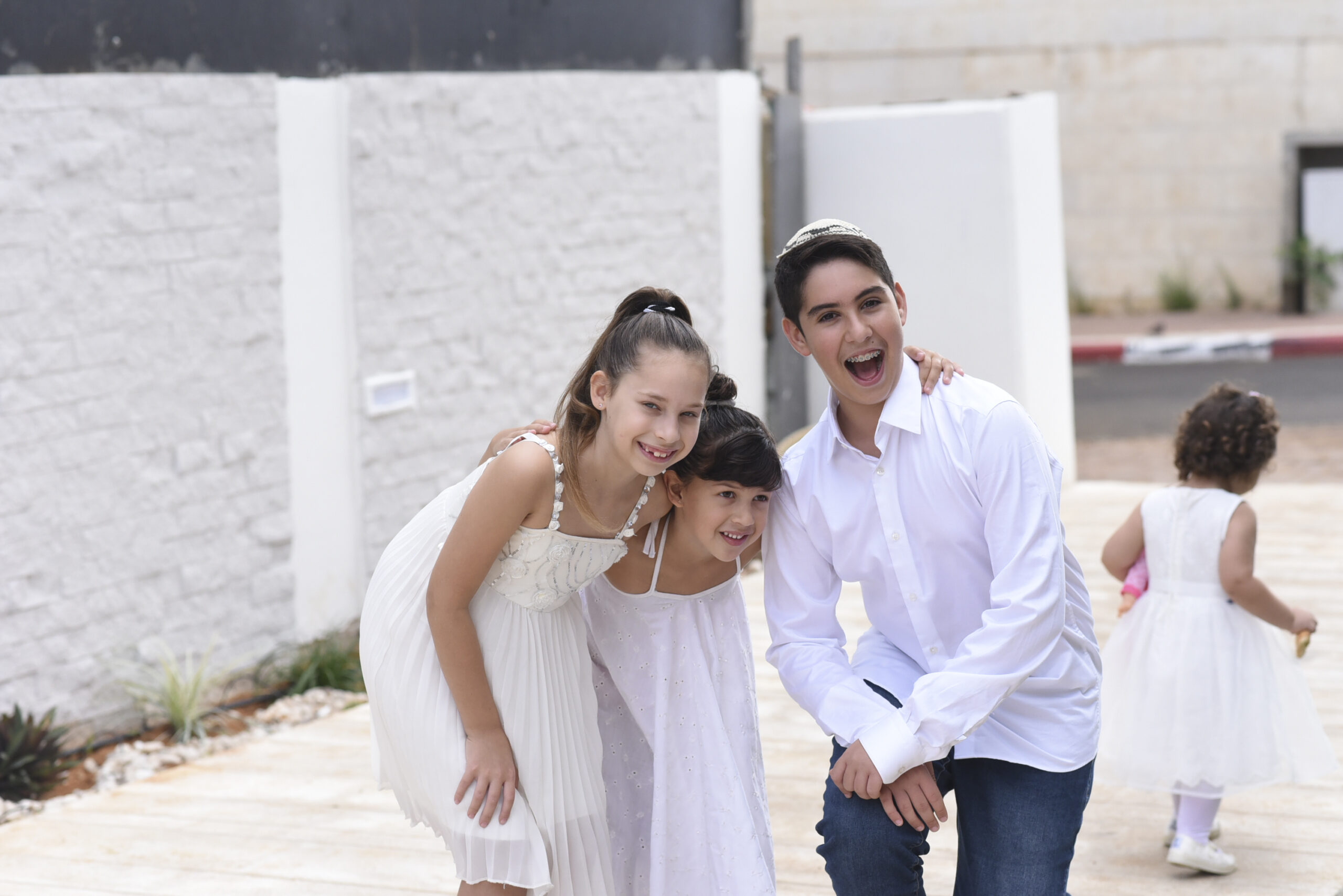 חתן בר המצווה עם האחיות – צילום משפחתי בחוץ